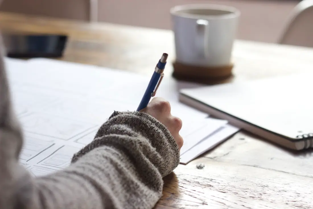 Personne qui rédige des documents à la main