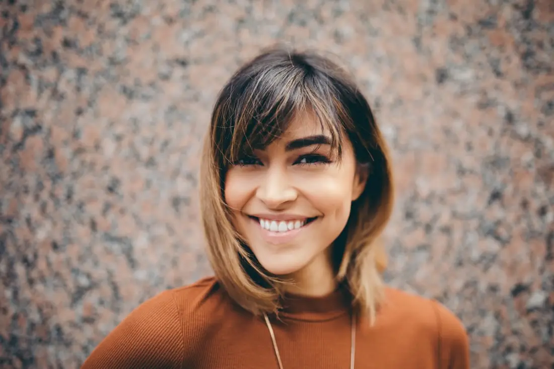 Jeune femme souriante et heureuse au téléphone