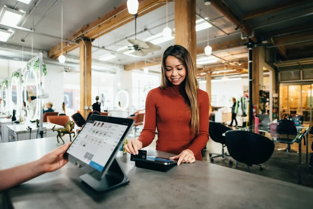 Entrepreneure qui sert un client dans son commerce