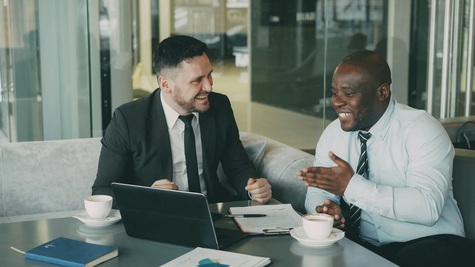 Avocat et entrepreneur souriants qui examinent un document autour d'un café